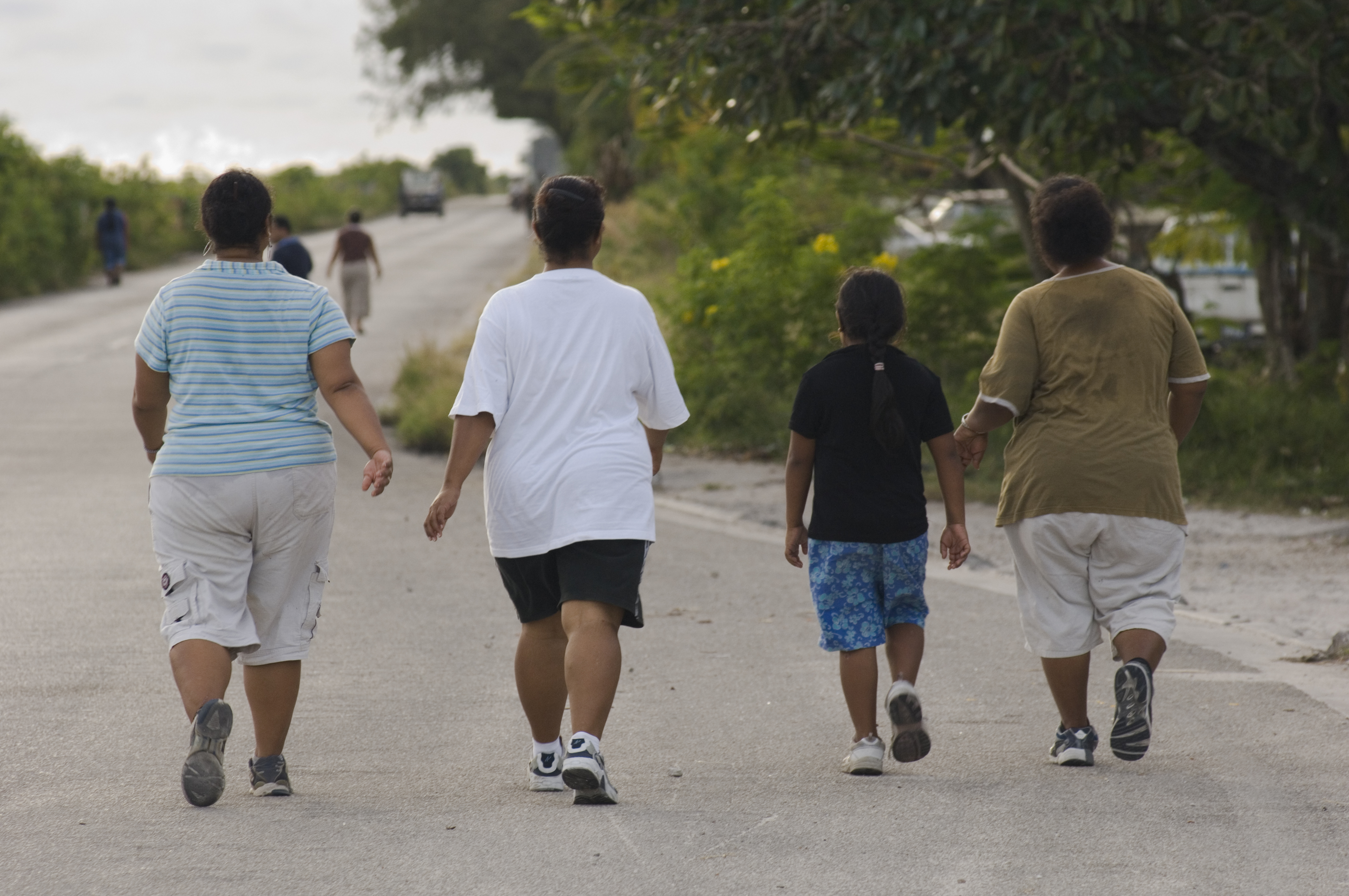 Warga Nauru berjalan di sekitar Bandar Udara Internasional Nauru. Orang Nauru termasuk yang paling gemuk di dunia.