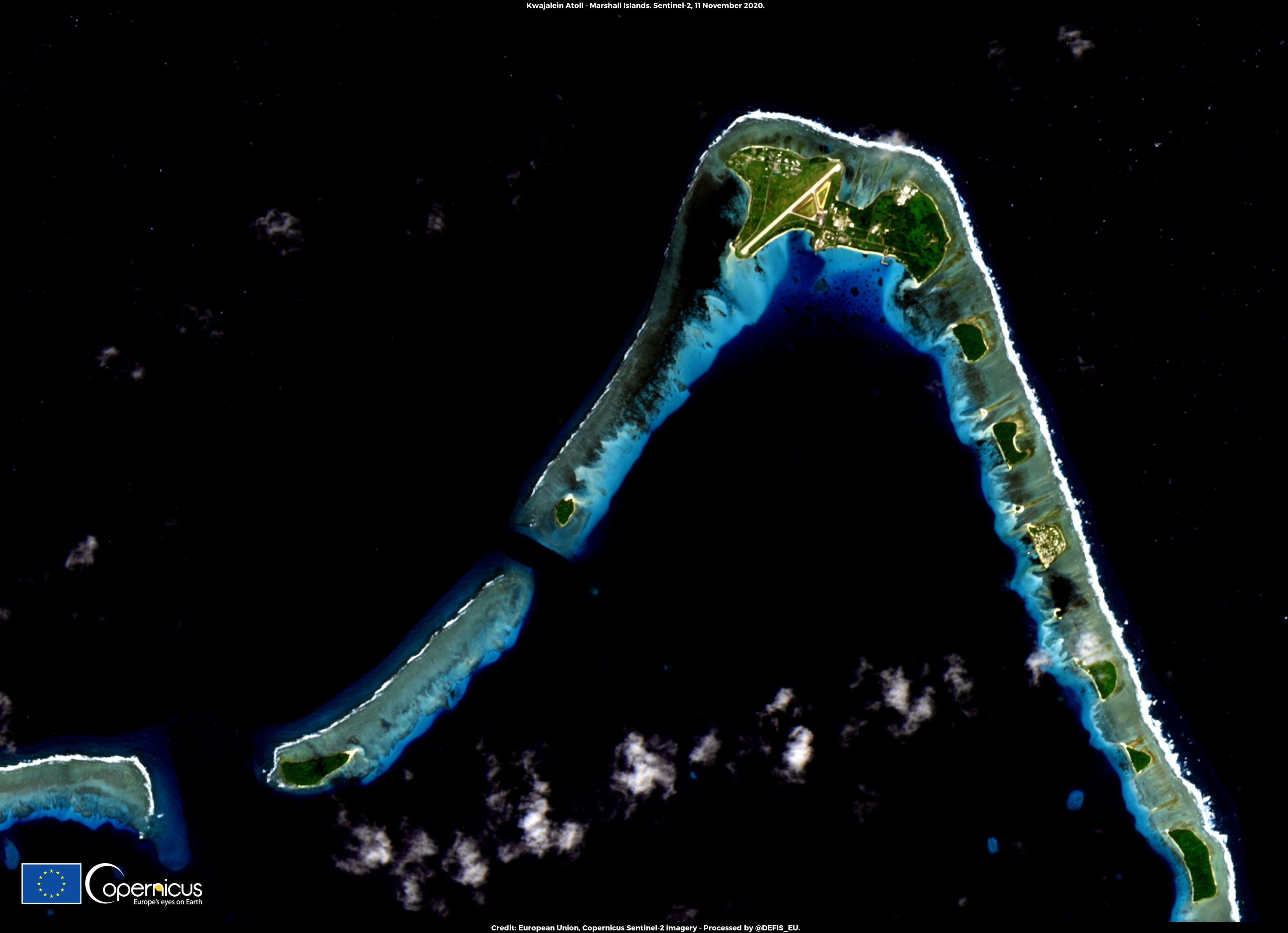 Pemandangan lebih dekat Atol Kwajalein menunjukkan geografi khas, pinggiran atol dihiasi dengan pulau-pulau karang yang mengelilingi laguna.