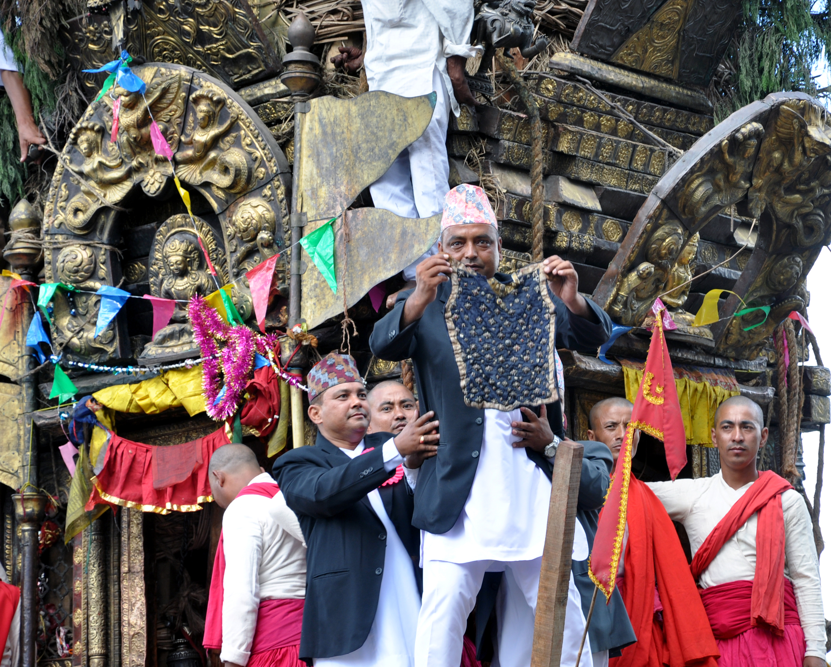 Seorang pria Nepal mengenakan Daura-Suruwal, mantel, dan topi Dhaka, memperlihatkan bhoto selama festival Bhoto Jatra.
