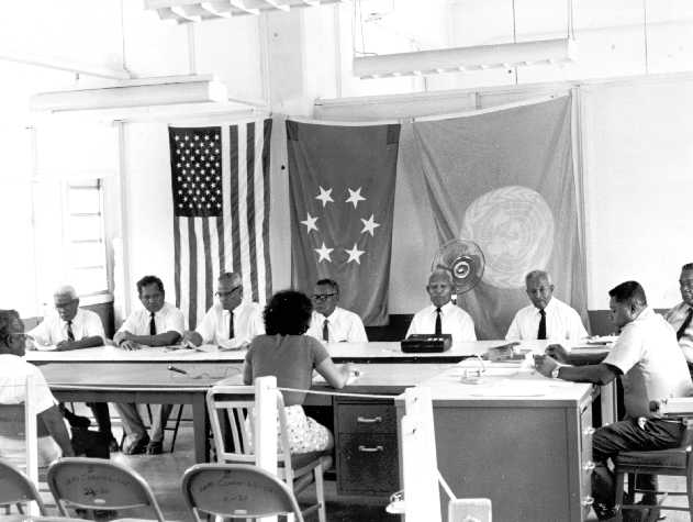 alt=Black and white photo of a legislative assembly in session.