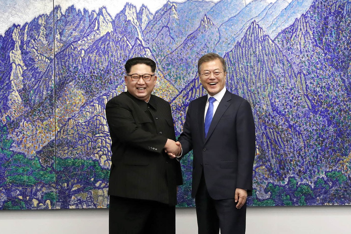 Pemimpin Korea Utara Kim Jong Un dan Presiden Korea Selatan Moon Jae-in berjabat tangan di dalam Rumah Perdamaian.