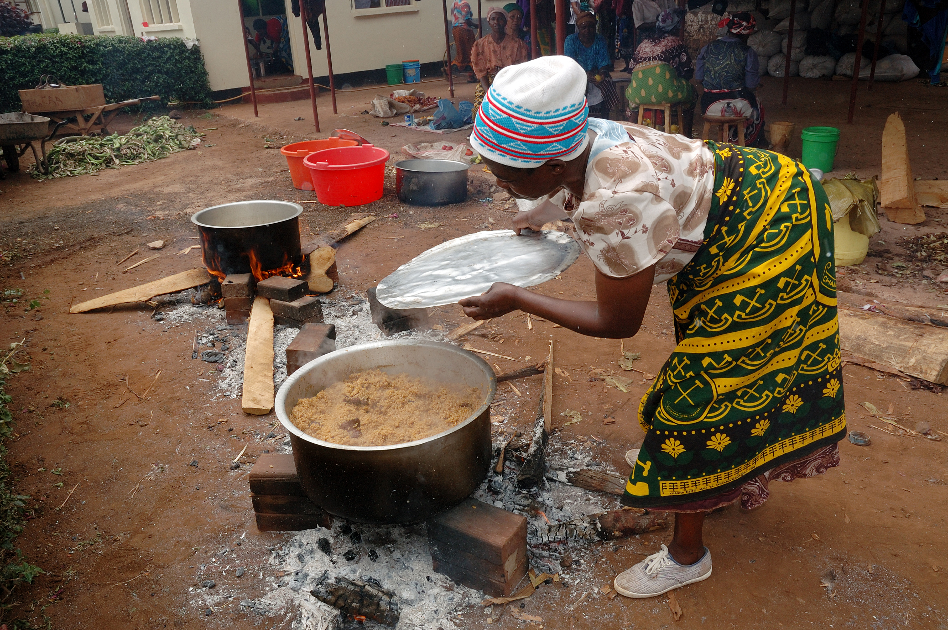 Một phụ nữ Tanzania nấu món cơm Pilau trong trang phục truyền thống Kanga.