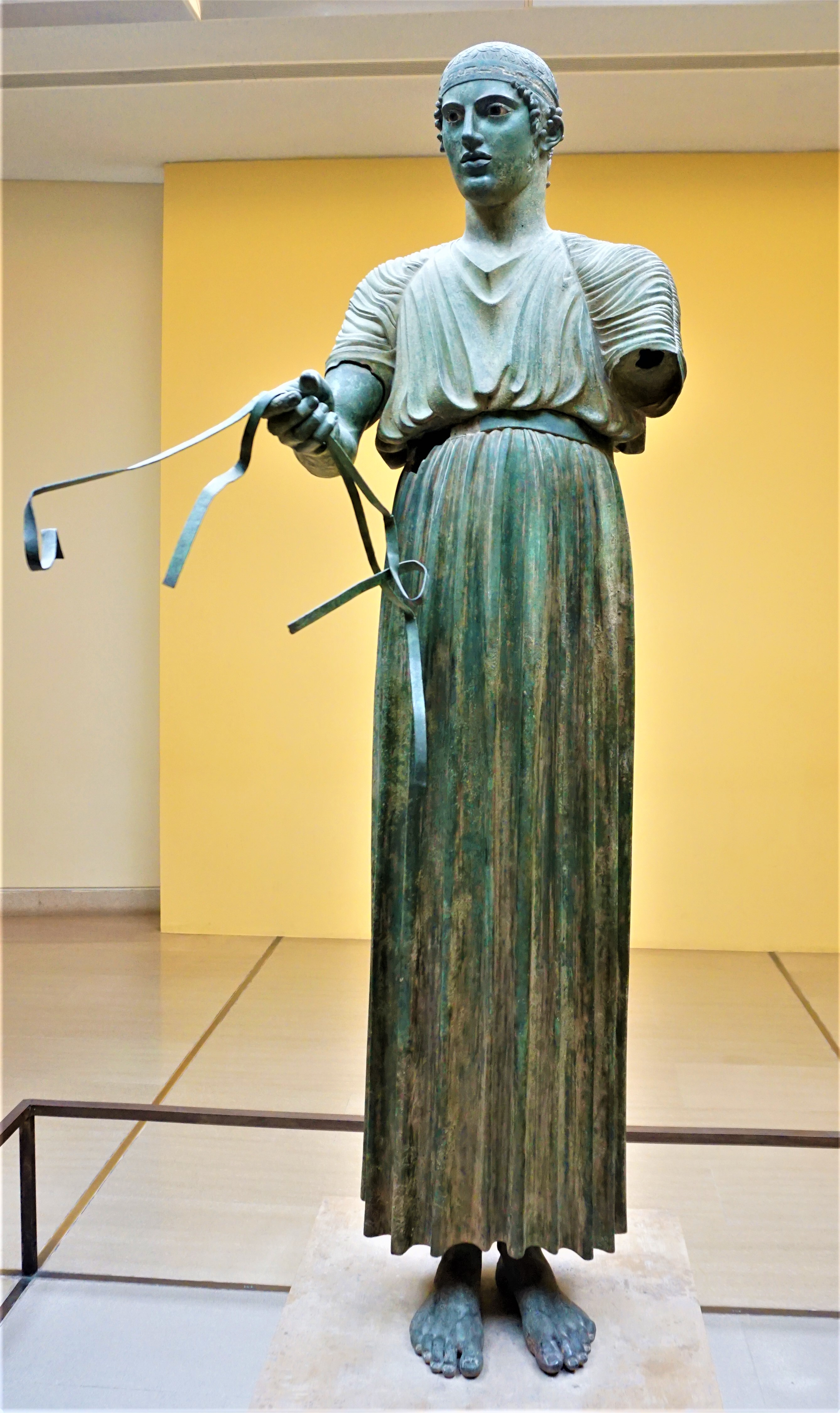 Patung pengendara kereta perang Delphi, mengenakan chiton.
