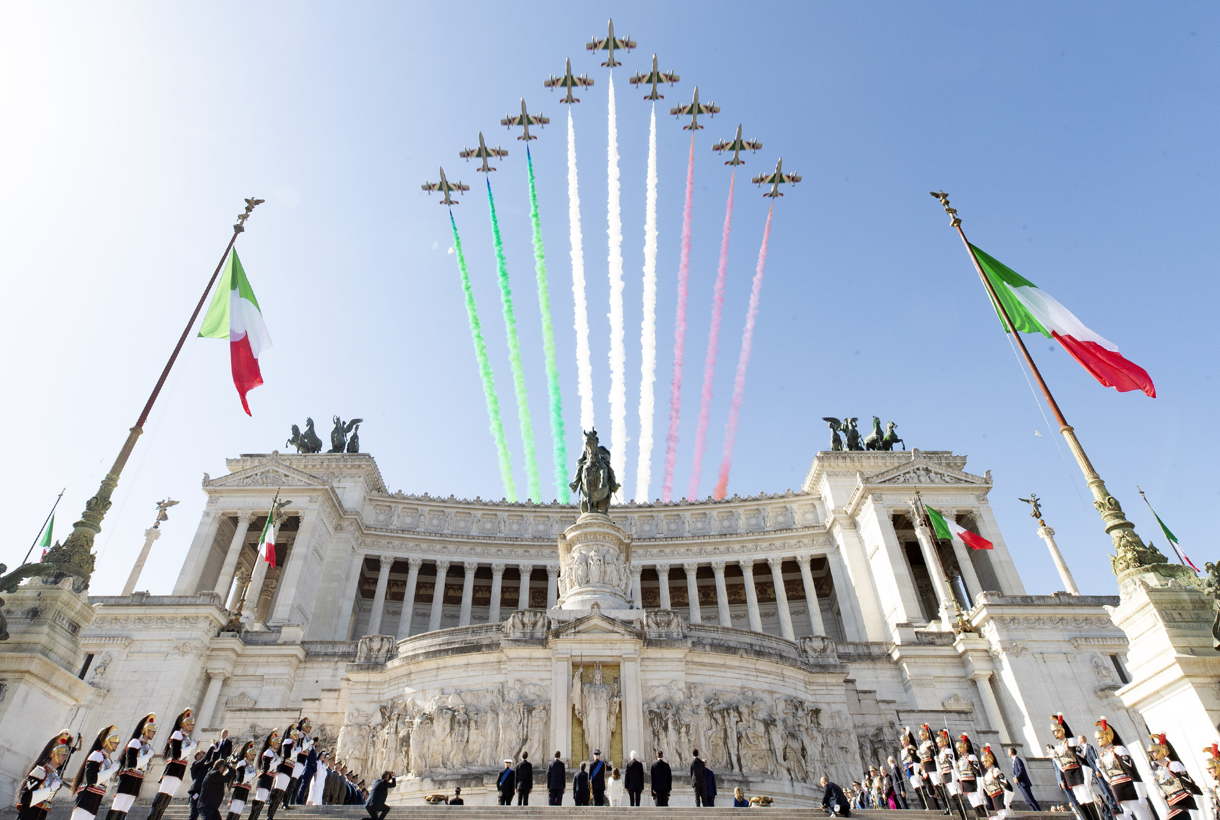 Frecce Tricolori, dengan jejak asap yang melambangkan warna nasional Italia, di atas Monumen Victor Emmanuel II di Roma selama perayaan Festa della Repubblica