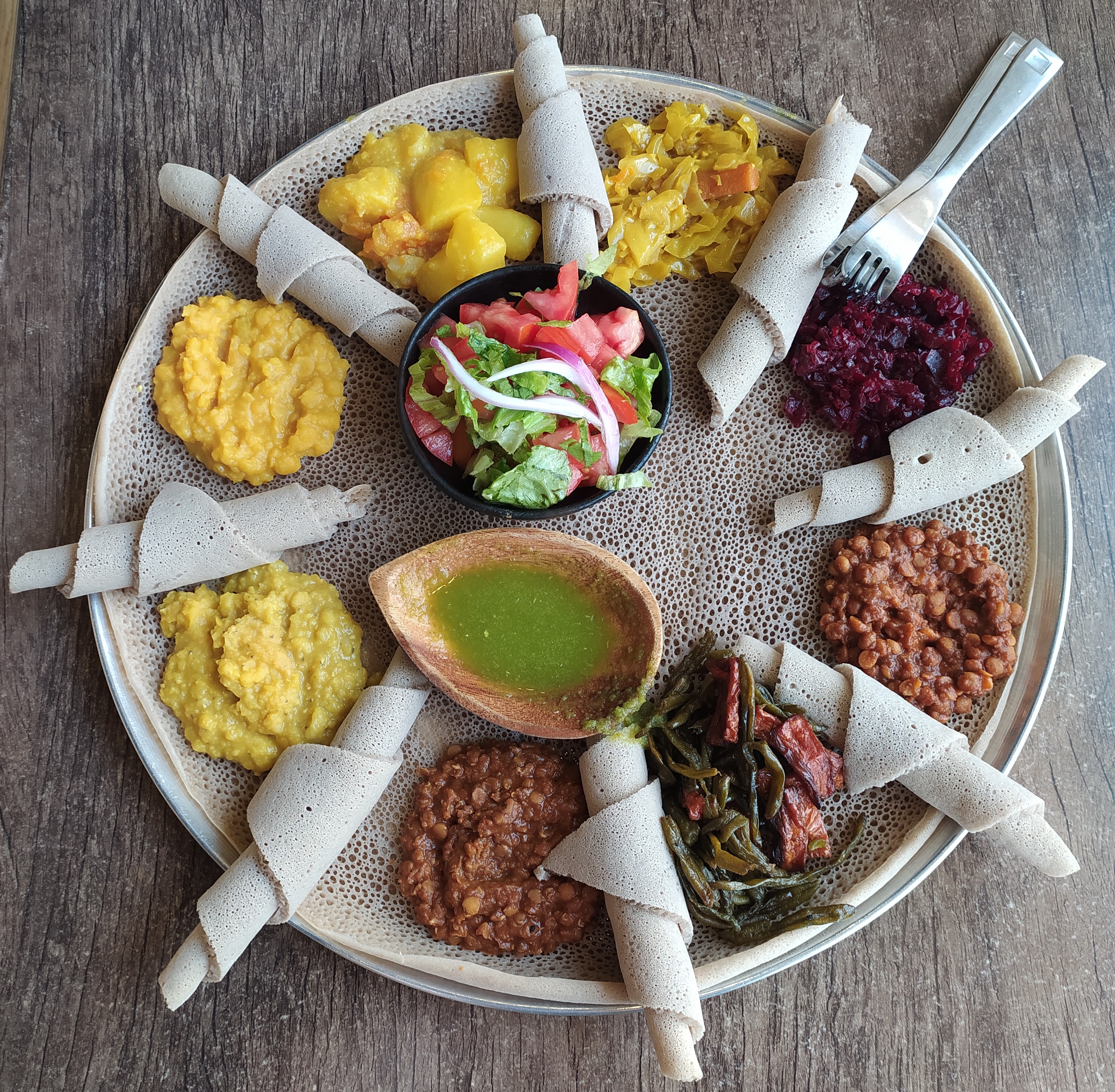 Hidangan ini terdiri daripada injera dan beberapa jenis wat (stu) adalah tipikal masakan Habsyah.