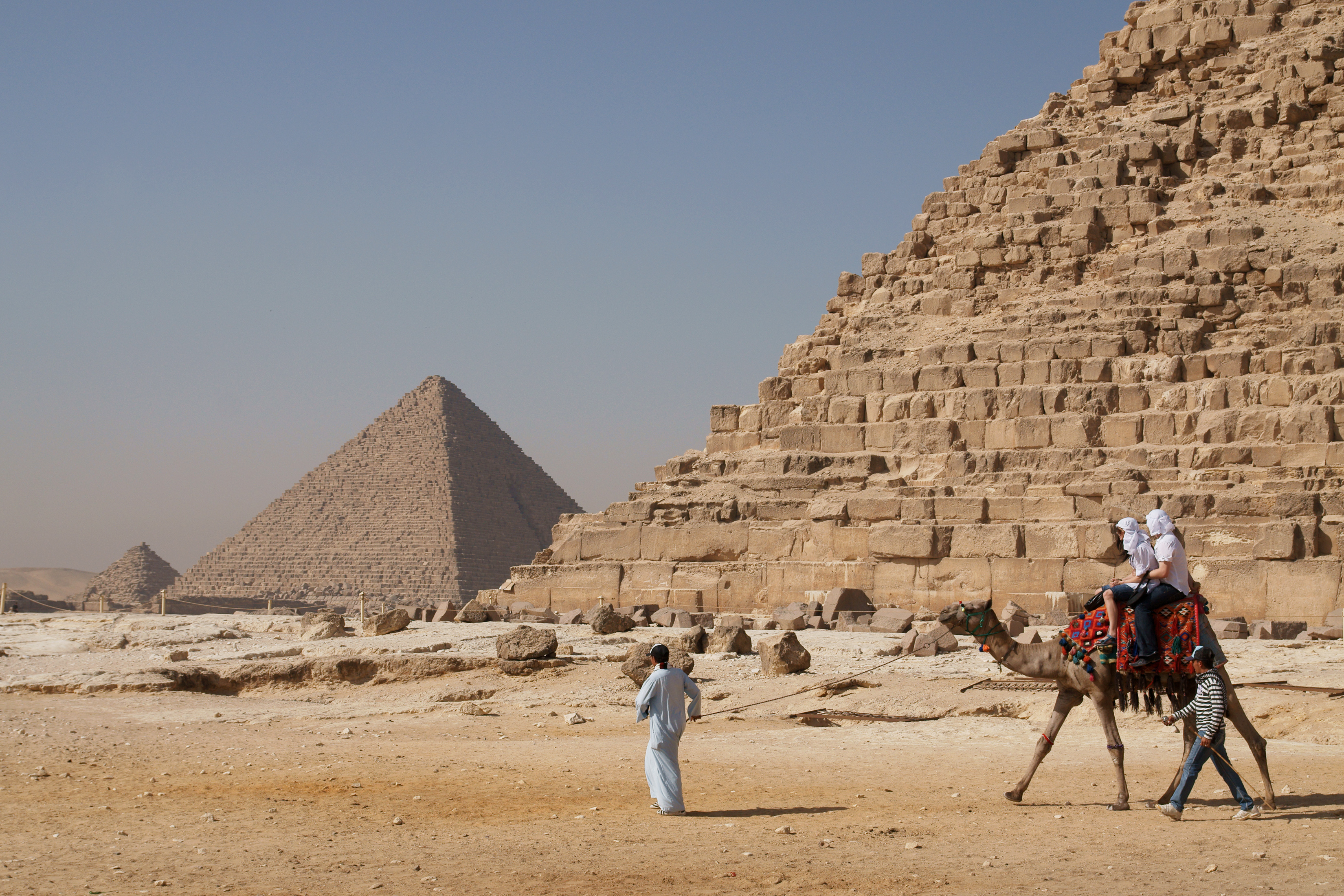Pelancong menunggang unta Arab di hadapan Piramid Khafre. Nekropolis Giza adalah salah satu tarikan pelancongan utama Mesir.