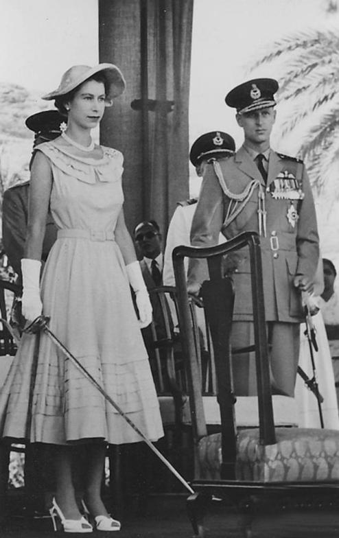 Ratu Elizabeth II memegang pedang, bersedia untuk memberi gelaran kesatria kepada rakyat di Aden sebagai sebahagian daripada lawatan 1954. Putera Philip, Duke Edinburgh berada di sebelah kanan.