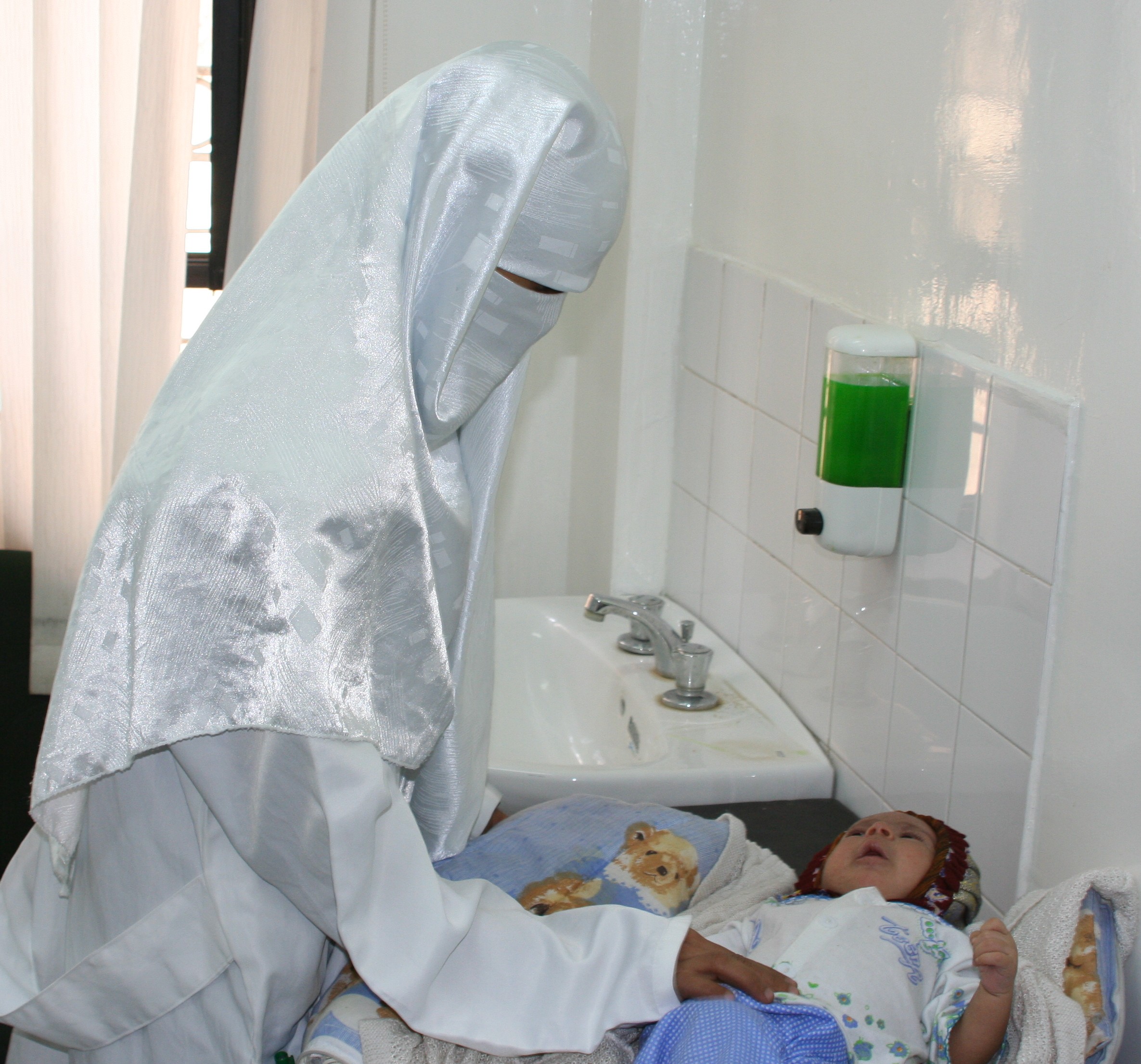 Seorang doktor Yaman memeriksa bayi di klinik penjagaan kesihatan yang ditaja USAID.