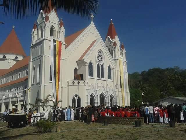 Gereja Igreja da Imaculada Conceição di Viqueque, menunjukkan dominasi arsitektur gereja Katolik dan kehadiran umat yang kuat.