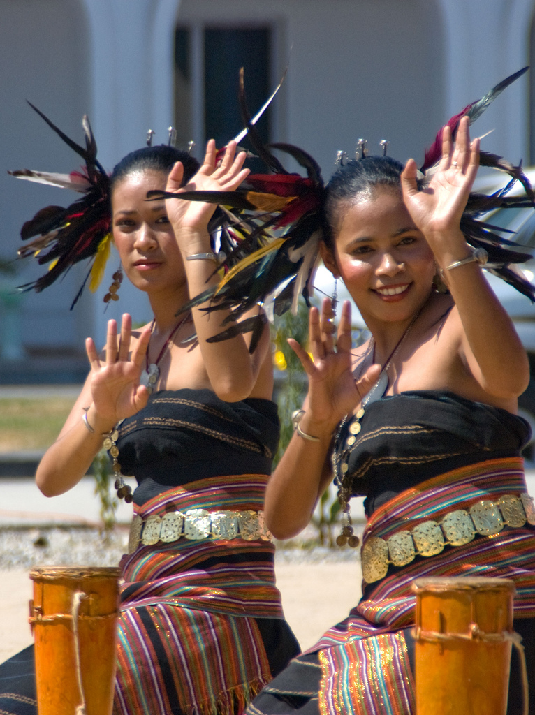 Penari tradisional Timor, menampilkan kostum yang menggabungkan bulu dan kain tais, mencerminkan kekayaan seni pertunjukan lokal.