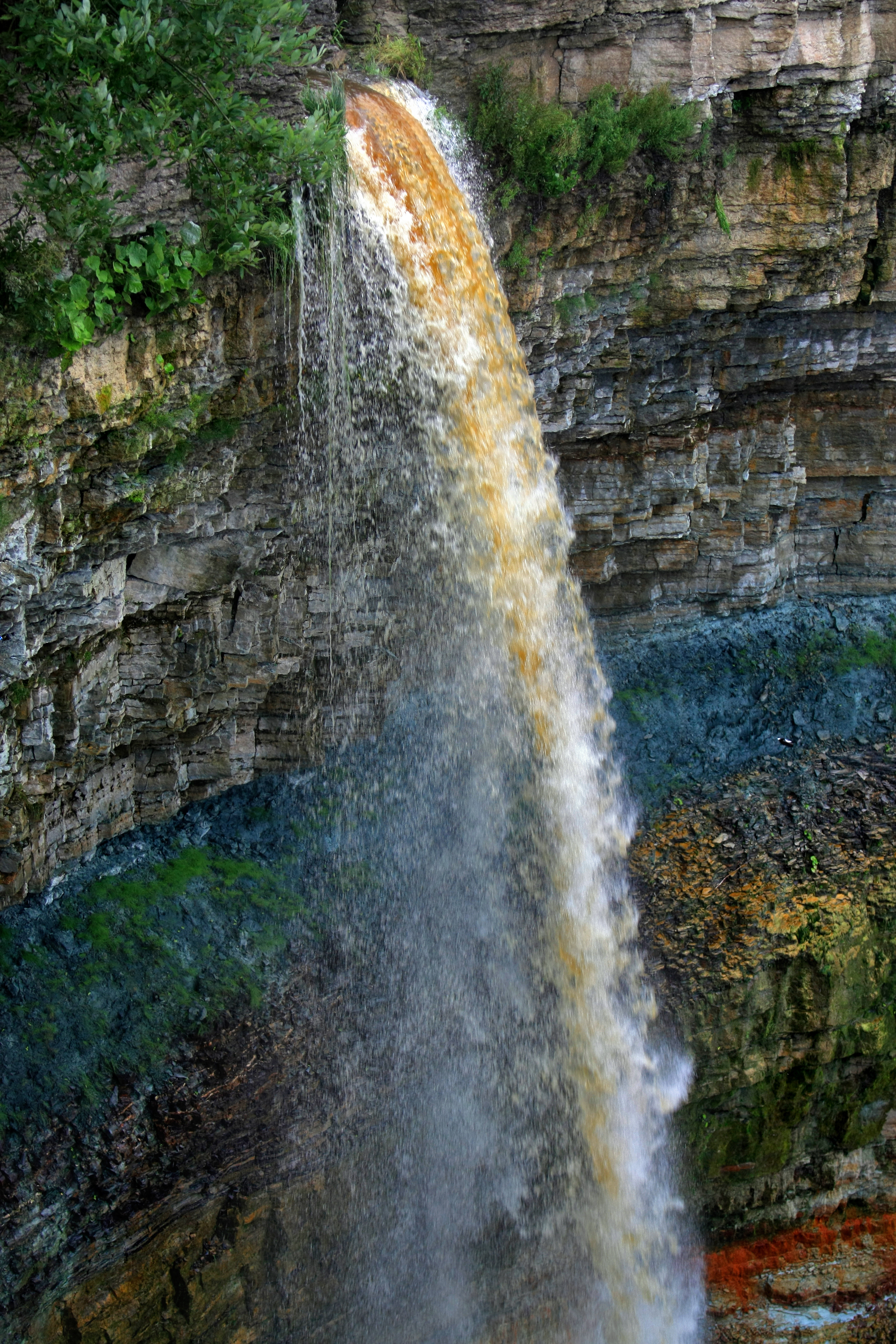 Tebing di Air Terjun Valaste menggambarkan stratigrafi pelbagai era geologi.