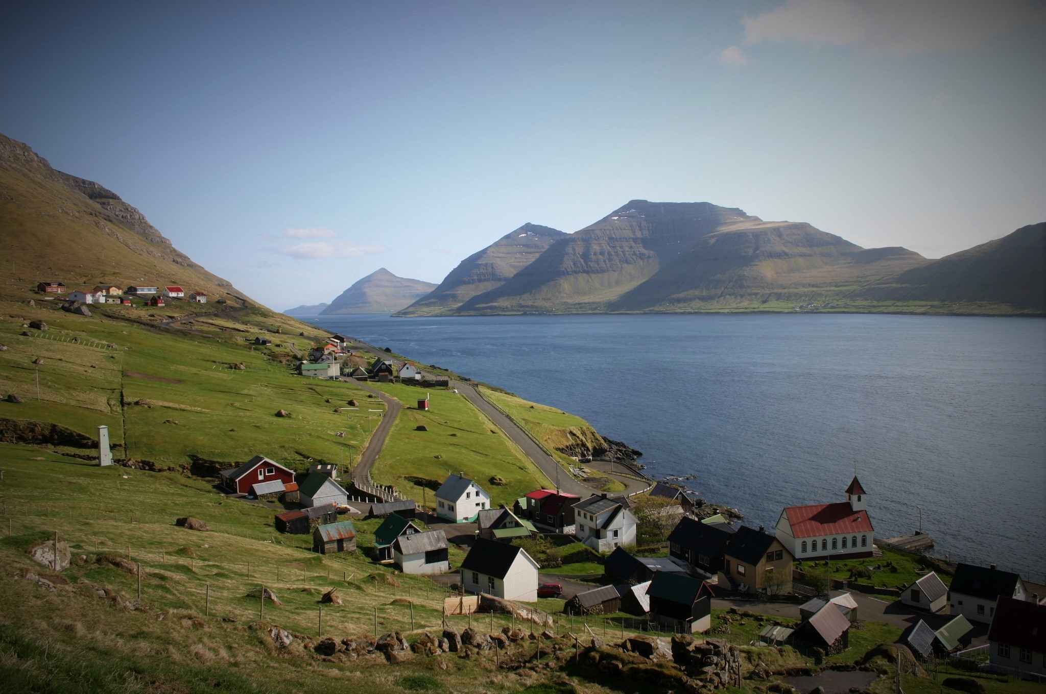 Desa Kunoy di pulau Kunoy, di Kepulauan Faroe. Pulau Kalsoy berada di sebelah kanan, menggambarkan lanskap unik wilayah otonom.