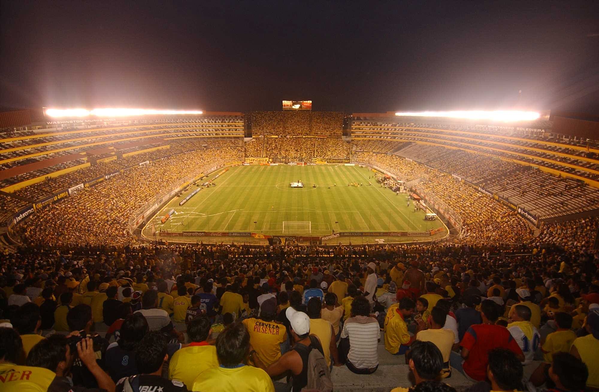 alt=Stadion sepak bola besar dengan banyak penonton