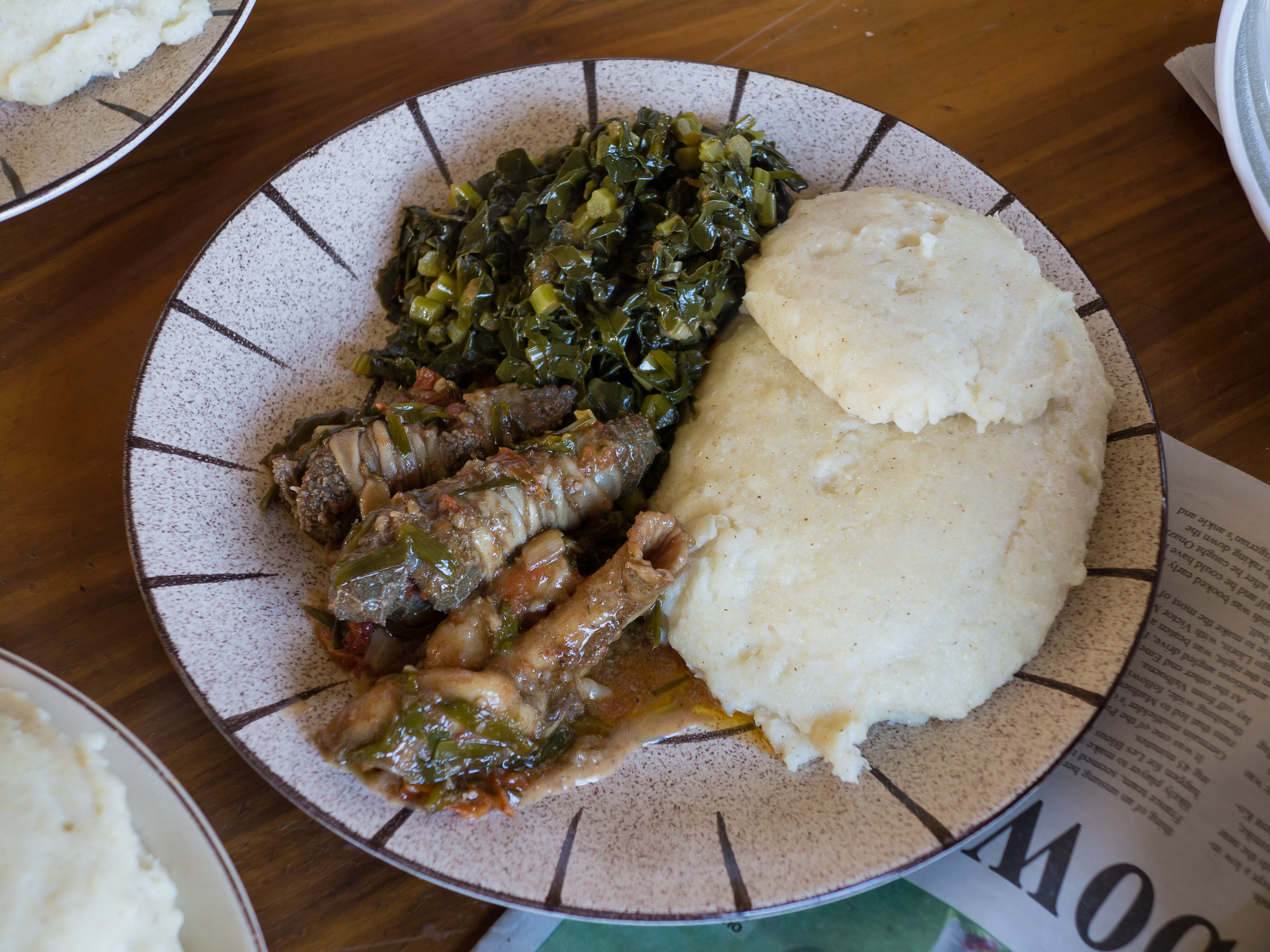 Hidangan sadza (kanan), sayur-sayuran, dan organ dalaman kambing. Usus kecil kambing dibalut di sekeliling kepingan kecil usus besar sebelum dimasak.