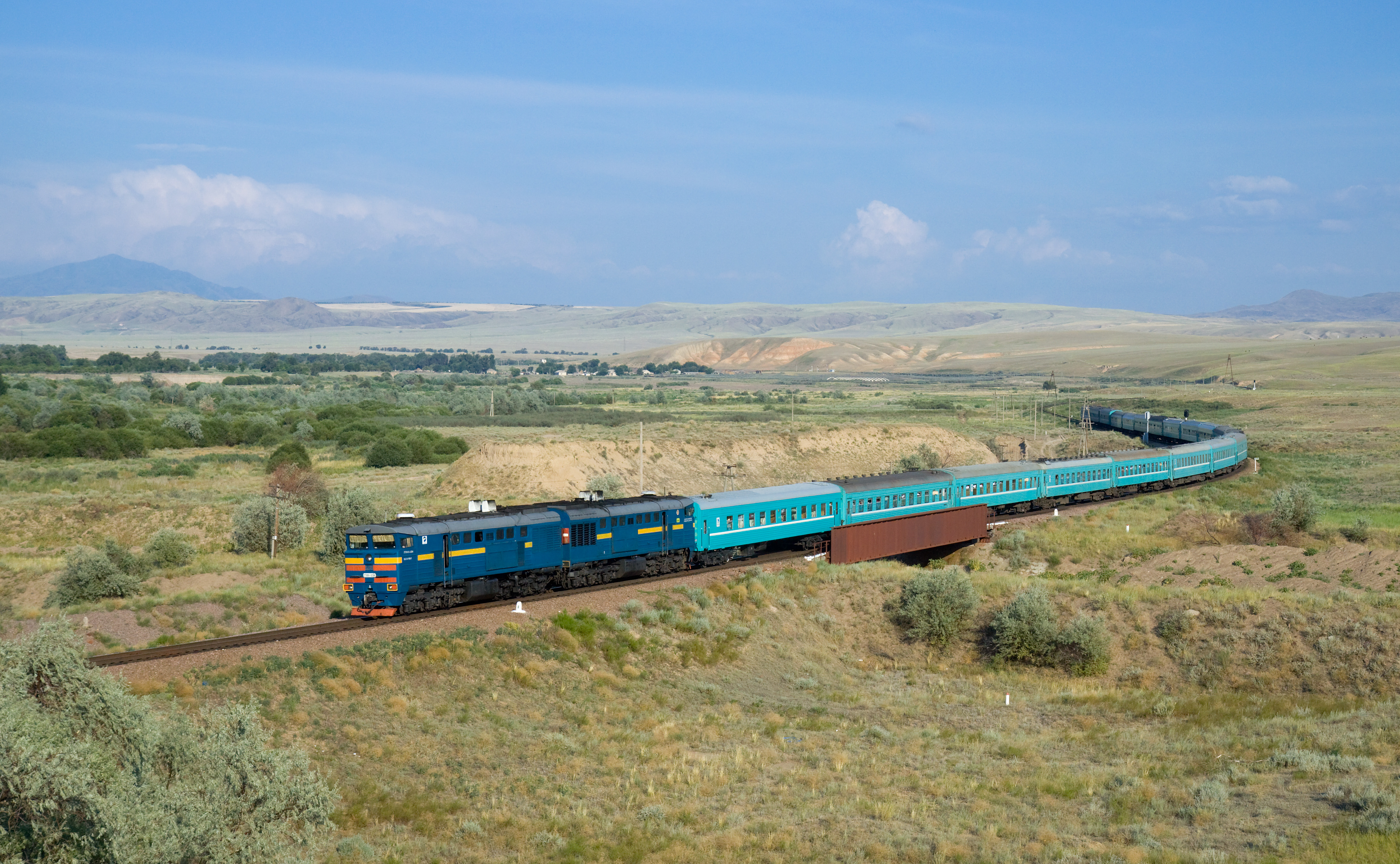 Kereta api 22 Kyzylorda - Semipalatinsk, ditarik oleh lokomotif diesel Kazakhstan Temir Zholy 2TE10U. Gambar diambil berhampiran Aynabulak, Kazakhstan.