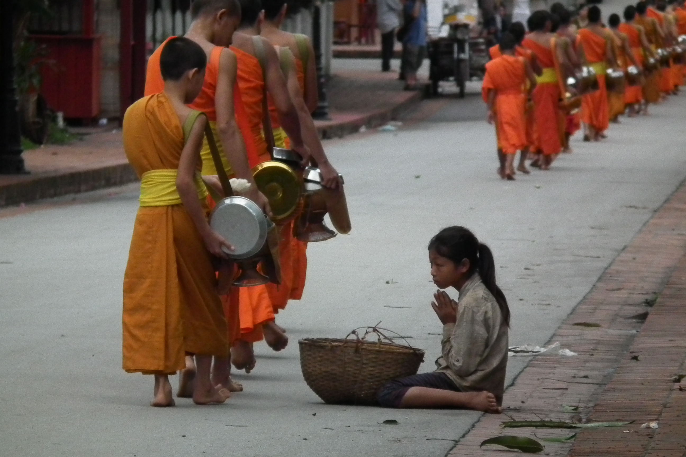 Pemberian sedekah kepada sami Buddha di Luang Prabang, satu amalan harian yang penting.