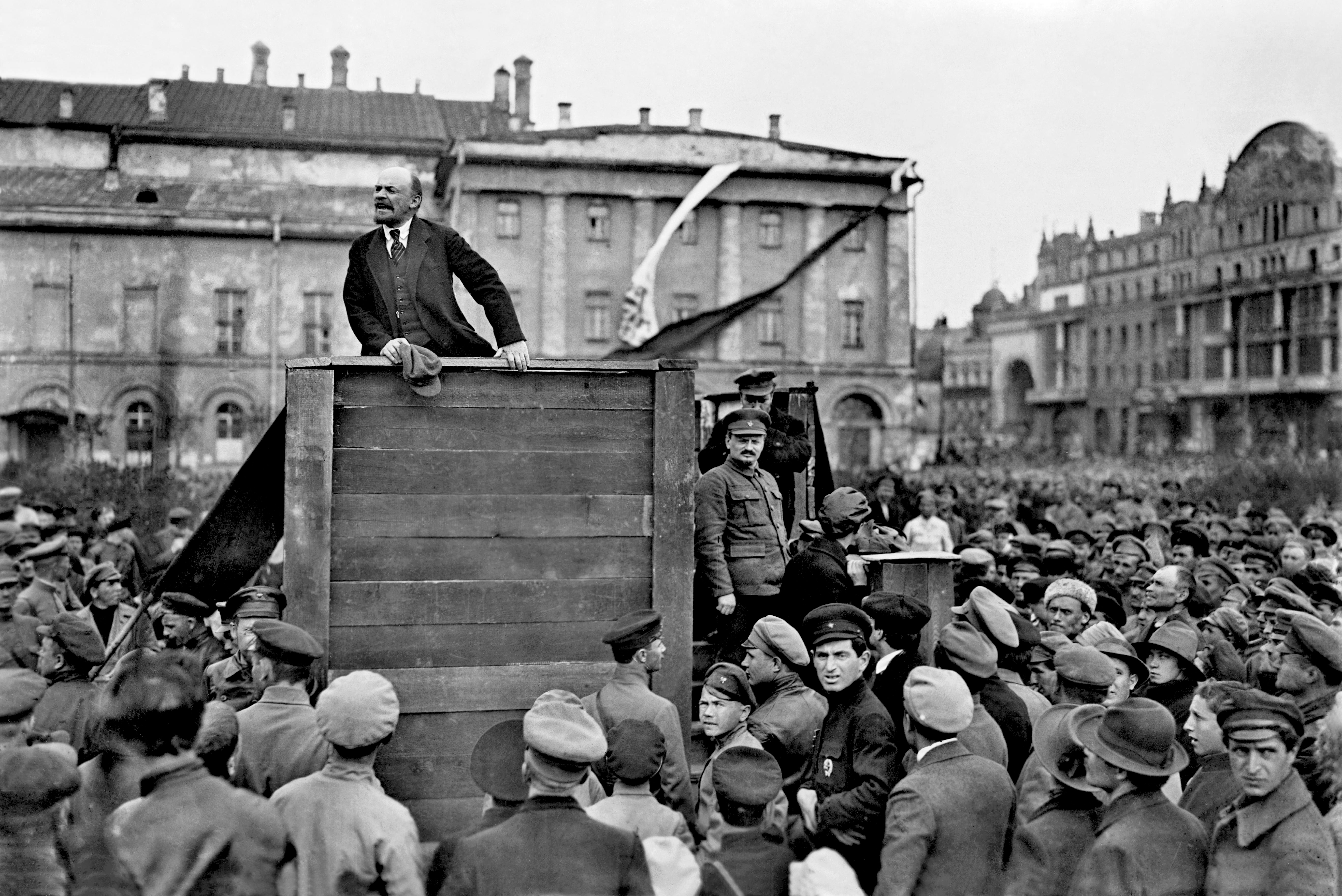 Vladimir Lenin berpidato di Moskwa, 1920, dengan Leon Trotsky bersandar di podium