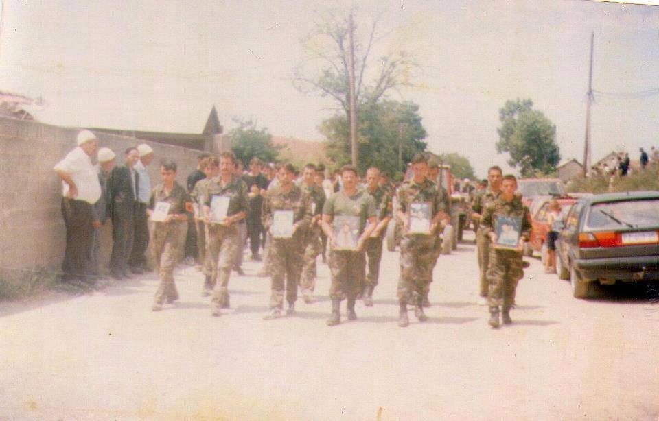Askar Albania Kosovo memegang gambar sebagai memperingati lelaki yang terbunuh atau hilang dalam pembunuhan beramai-ramai Krusha.