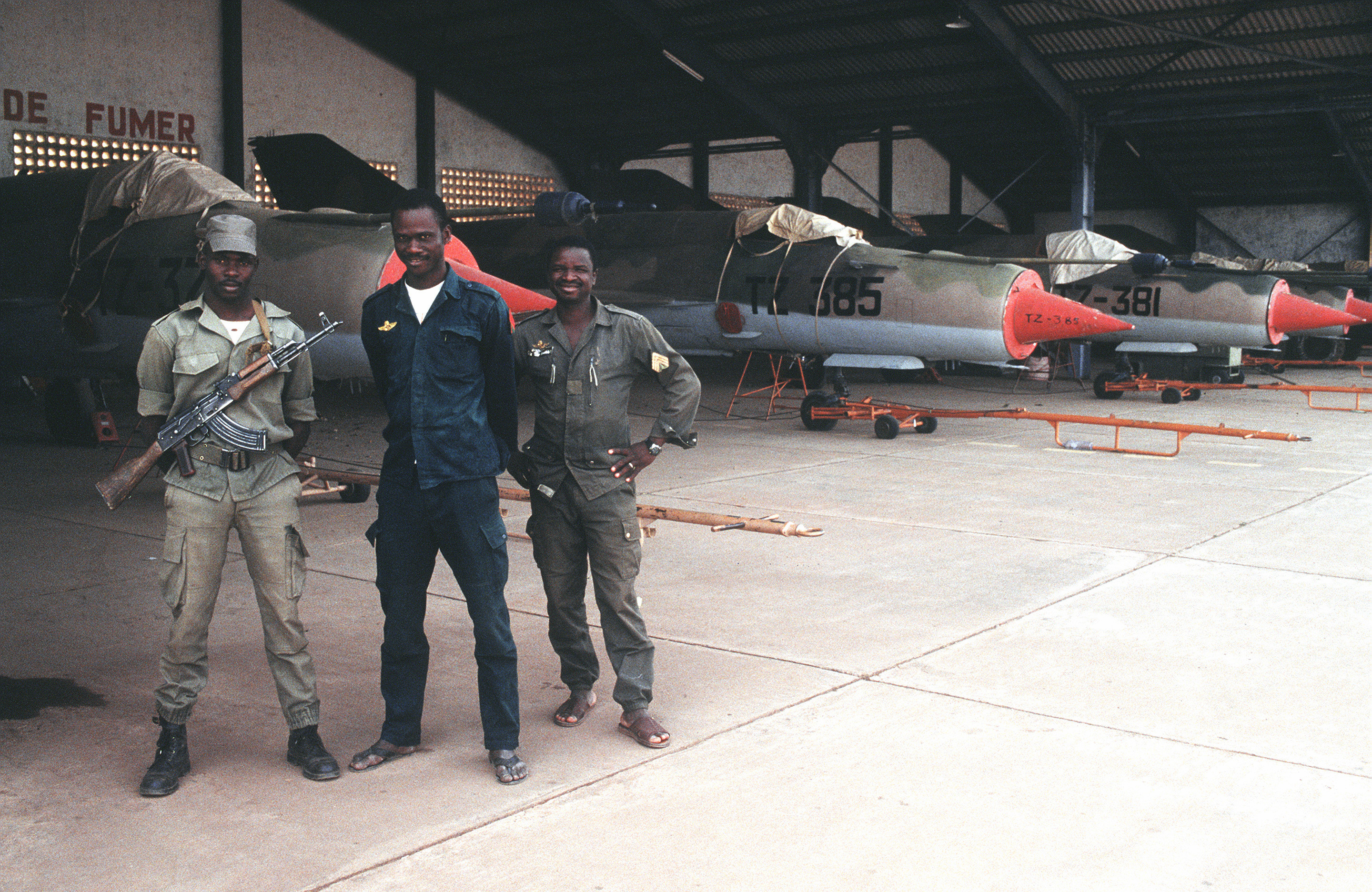 Tentara Mali berdiri di belakang pesawat tempur MiG 21bis di bandara Bamako.