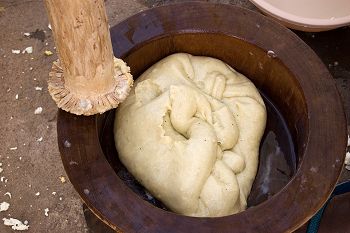 Traditional preparation of Fufu, a staple food in parts of West Africa, often made from cassava, yams, or plantains. Rice is the primary staple in Guinea.