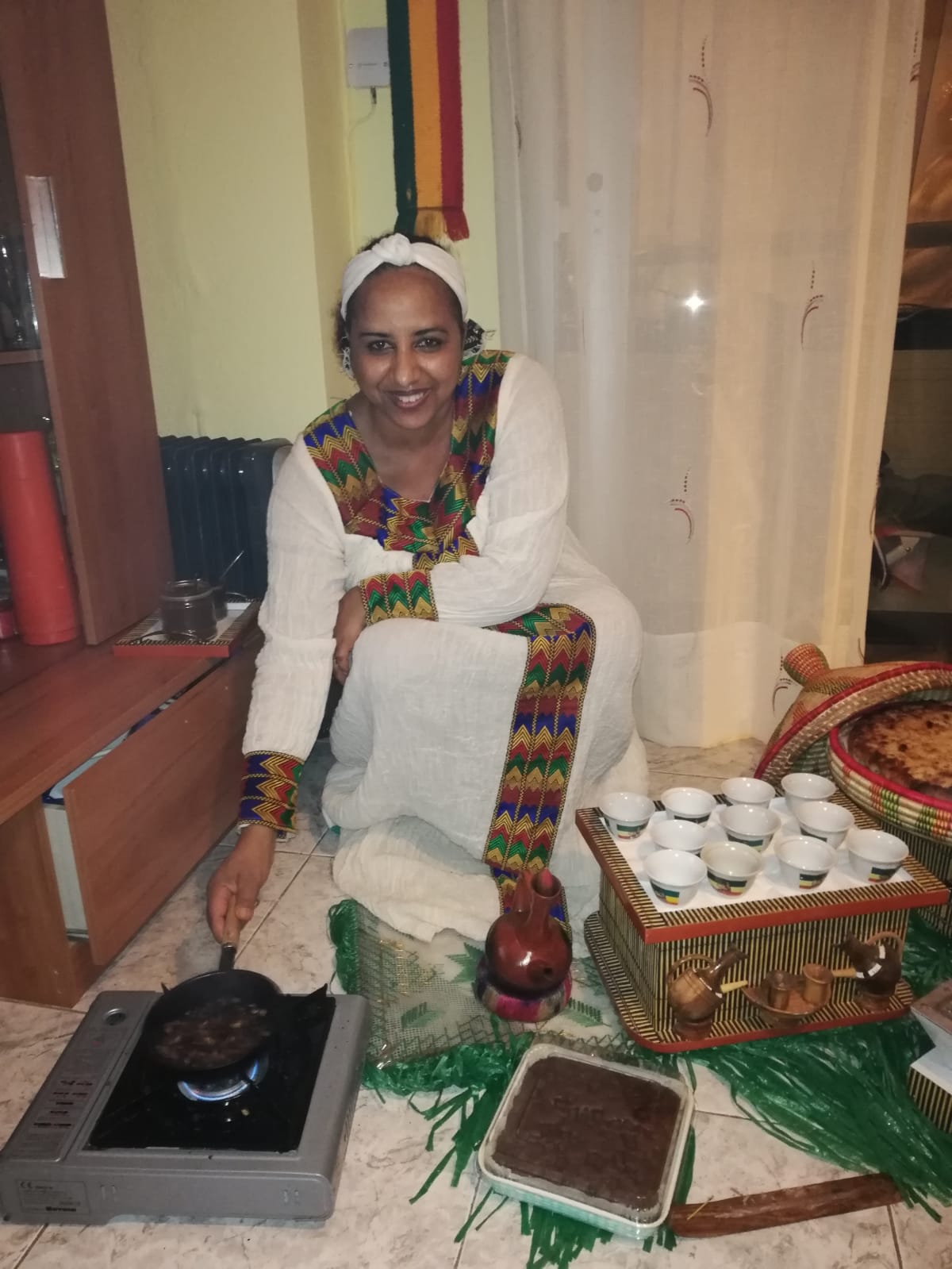 Seorang wanita Ethiopia memanggang biji kopi di sebuah kedai kopi. Upacara penyajian kopi adalah hidangan terpenting di Ethiopia.
