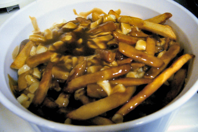 Poutine, hidangan populer dari Quebec yang terdiri dari kentang goreng, dadih keju, dan saus cokelat.